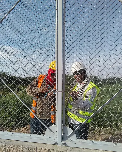 Montaje en obra — Fijación de la malla al poste por el equipo técnico — Metalworks Energy