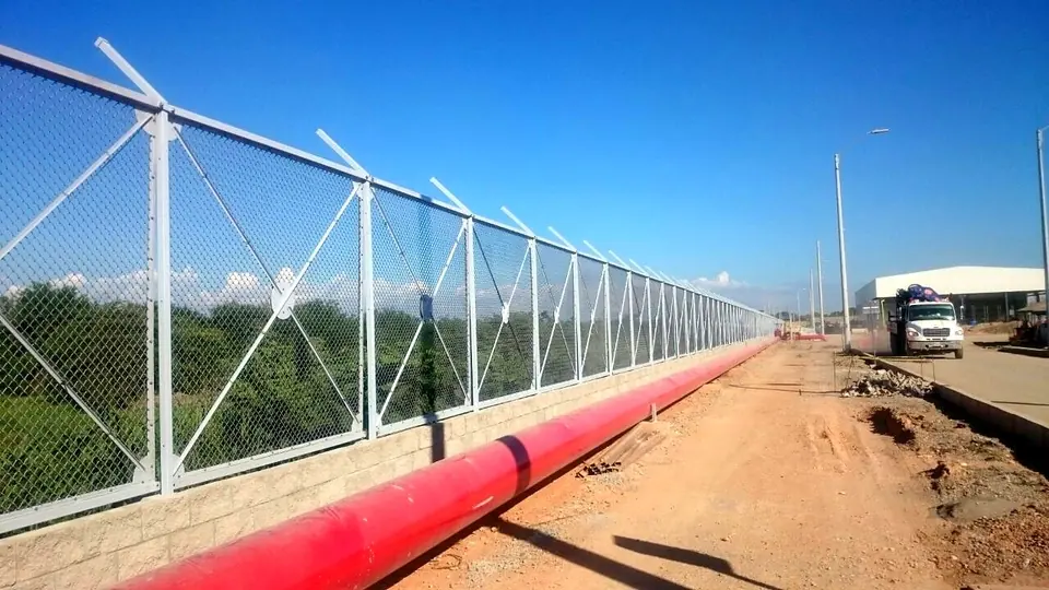 Cerramiento en zona industrial — Malla galvanizada con remate en bayoneta sobre muro — Metalworks Energy