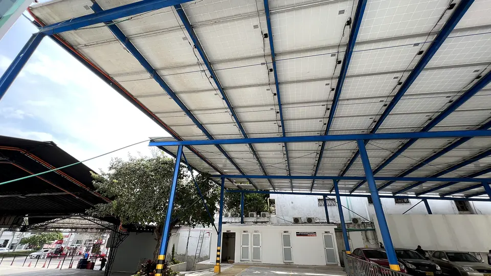 Cubierta solar comercial — Módulos sobre zona de parqueo y servicios — Metalworks Energy