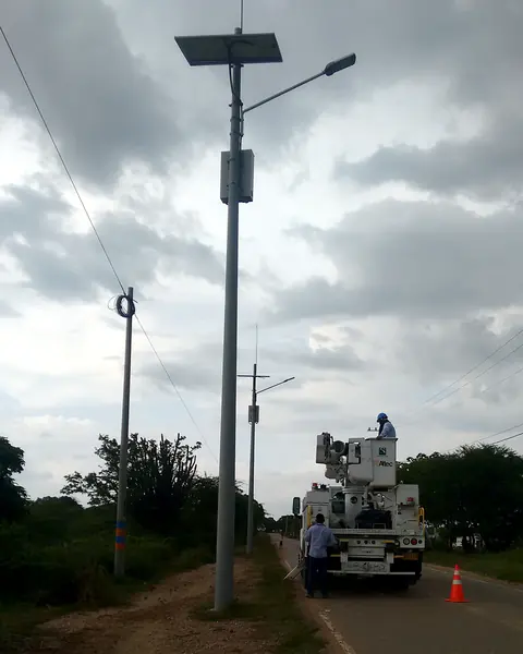 Montaje de alumbrado solar — Equipo técnico instalando luminarias en vía — Metalworks Energy